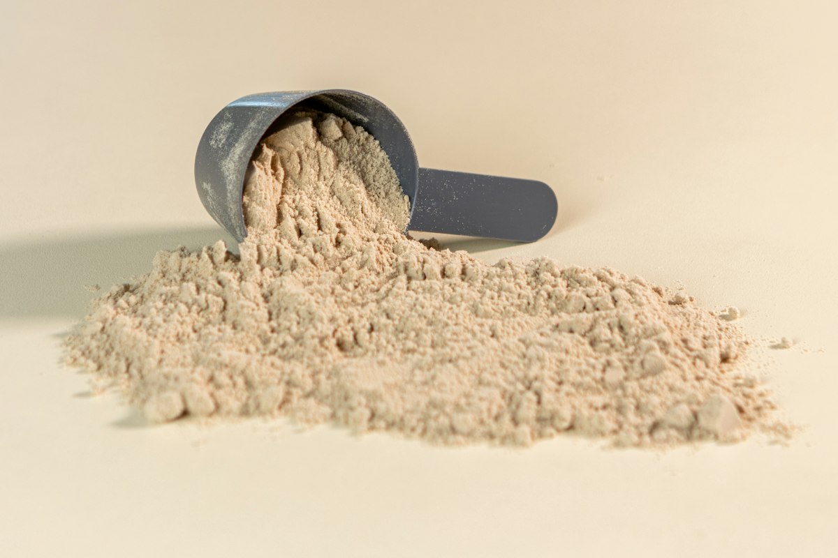 Powder supplement with measuring scoop